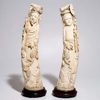 Een paar grote Chinese ivoren sculpturen van een man en vrouw met vissen, 19/20e eeuw